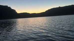 A calm lake with a boat in the foreground and hills in the background. - RuneStone Ranch: on Lake Cumberland, Upper Level, Russell Springs (Russell Springs)