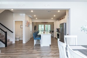 A spacious kitchen with a central island, white cabinetry, and a stainless steel refrigerator. - Welcoming 4BR Villa with Pool in Charming Frankford (Frankford)