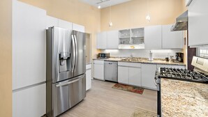 A modern kitchen with stainless steel appliances, white cabinetry, and a granite countertop. - Spacious Retreat Near Boston with AC, Roku, Deck, BBQ Grill + Pet Friendly! (Framingham)