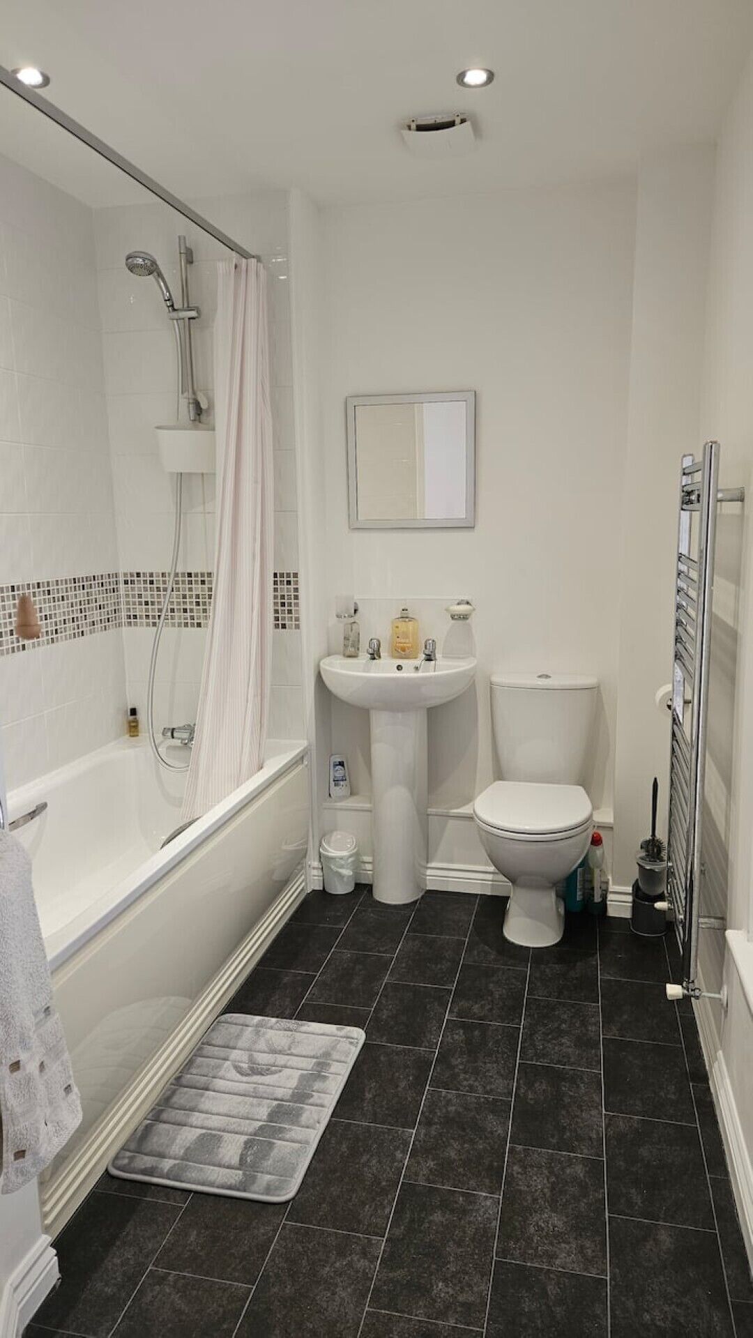 A bathroom with a bathtub, toilet, sink, and shower.