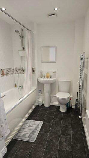 Un baño con bañera, inodoro, lavabo y ducha.