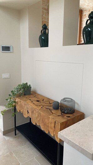 A wooden console table with a plant and a glass jar. - Il Villino - Luxury Country House, a luxury retreat between nature and tradition (Puglia)