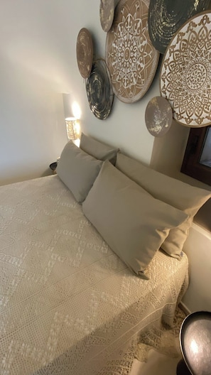A bed with beige bedding, a patterned throw, and a wall-mounted lamp. - Il Villino - Luxury Country House, a luxury retreat between nature and tradition (Puglia)