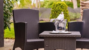 A wicker table with a clear glass and a white napkin.