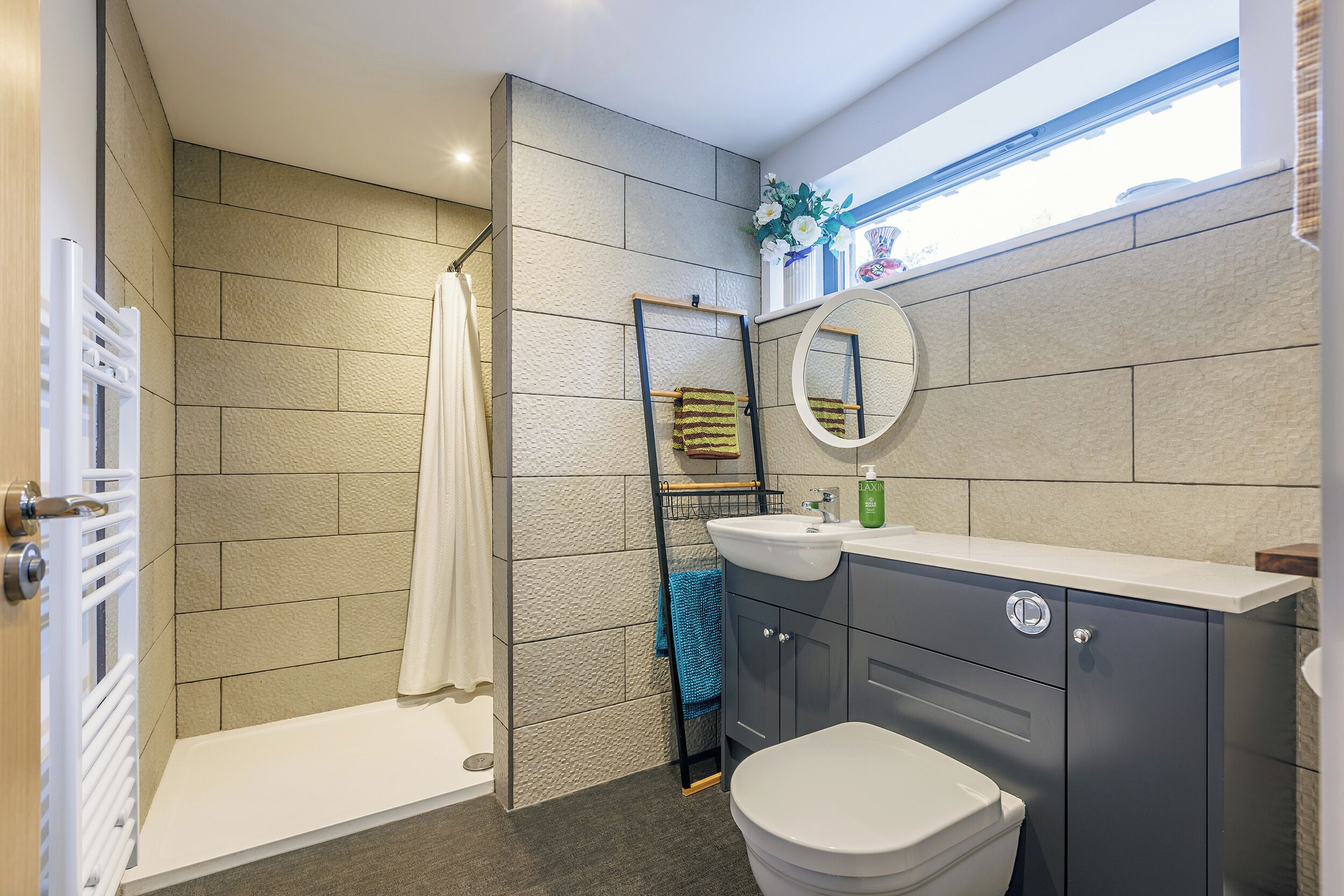 A modern bathroom with a shower, toilet, and vanity.