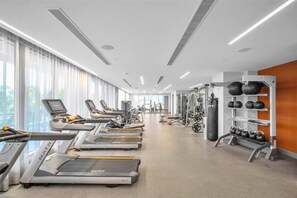 A modern gym with treadmills, weight machines, and kettlebells. - Modern Studio | Pool View | Downtown Doral' Heart (Doral)