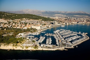 An aerial view of a coastal city with a marina, buildings, and mountains in the background. - 106 luxury room in the heart of Split with balcony and roof terrace (Split)