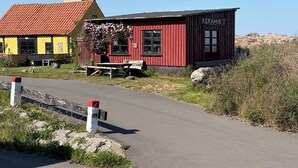Een rood gebouw met een bord waarop 'KERAMIK' staat en een hoge stenen schoorsteen.