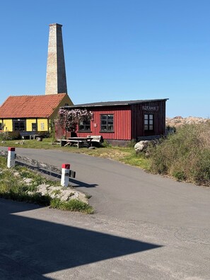 A red building with a sign reading 'KERAMIK' and a tall stone chimney. - Lovely holiday apartment near centre (Allinge)