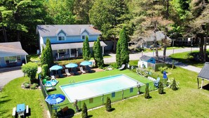A residential property with a swimming pool, lounge chairs, and a covered patio area. - Bonnie 1 Cottage/Resort/Orillia, Muskoka (Washago)