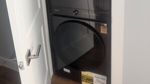 A compact washer and dryer unit with a Samsung label, a QR code, and a price tag.