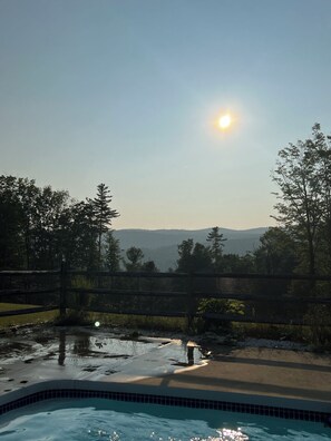 Une piscine offrant une vue sur les montagnes et les arbres au loin.