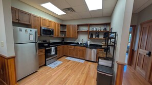 A kitchen with wooden cabinets, stainless steel appliances, a microwave, and a coffee maker.