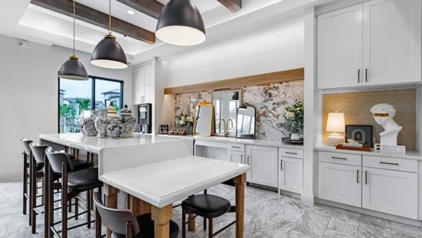 A modern kitchen with a central island, bar stools, pendant lighting, and a marble backsplash. - Landing | Beautiful 1BD, Clubhouse (McKinney)