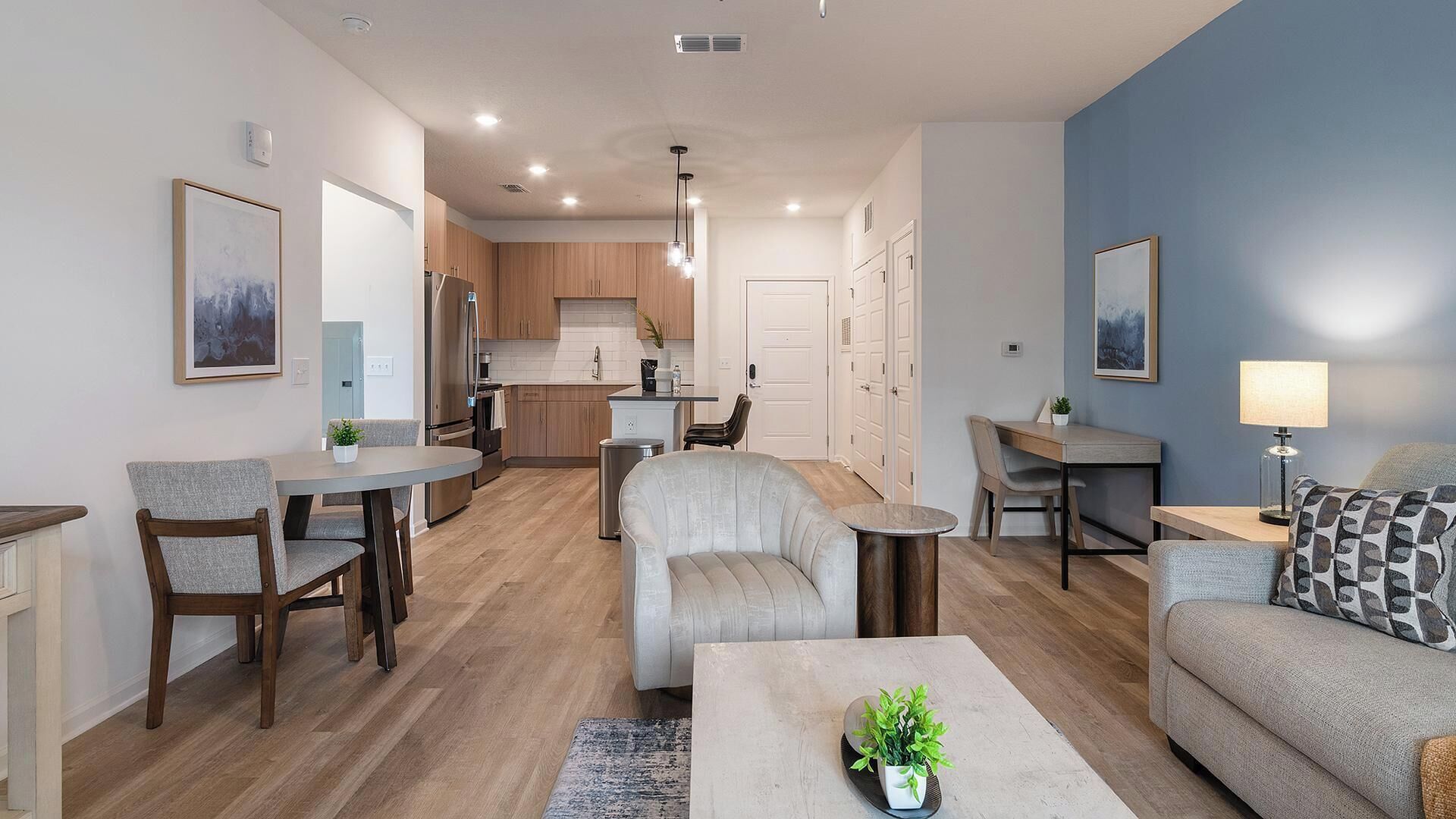 A modern apartment with a dining area, kitchen, and living room.