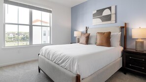 A bedroom with a large window, a bed with white bedding, two bedside lamps, and a wall-mounted abstract art piece. - Landing | Incredible 1BD, Gym, Clubhouse (Kissimmee)