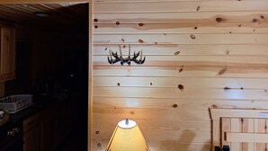 A wooden interior with a wall-mounted light fixture and a door.