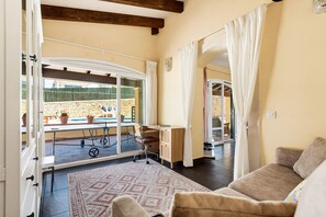 A room with a view of a pool, a cart, a desk, and a sofa. - Villa Lamar - Three Bedroom Villa, Sleeps 6 (Alayor)