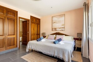 Ein Hotelzimmer mit einem großen Bett, einem Holzschrank und einem Gemälde an der Wand.