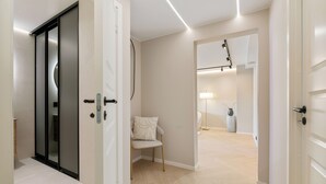 A modern hallway with a chair, a lamp, and a mirror. - Modern 3BR apartment | Free parking | 10 min to centrum (Trondheim)