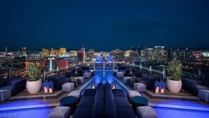 A rooftop lounge with a city view, featuring a pool, seating areas, and potted plants. - Incredible Views 51st Floor High-Rise Studio -Balcony (Las Vegas)