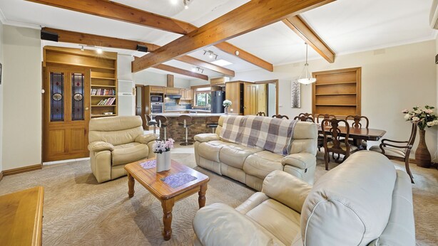 A spacious living area with leather sofas, a wooden coffee table, and a dining table with chairs. - Huge 5 Bed Party House: Pool/Renovated Tram/Bar/Games Room/Family Stay (Clyde)