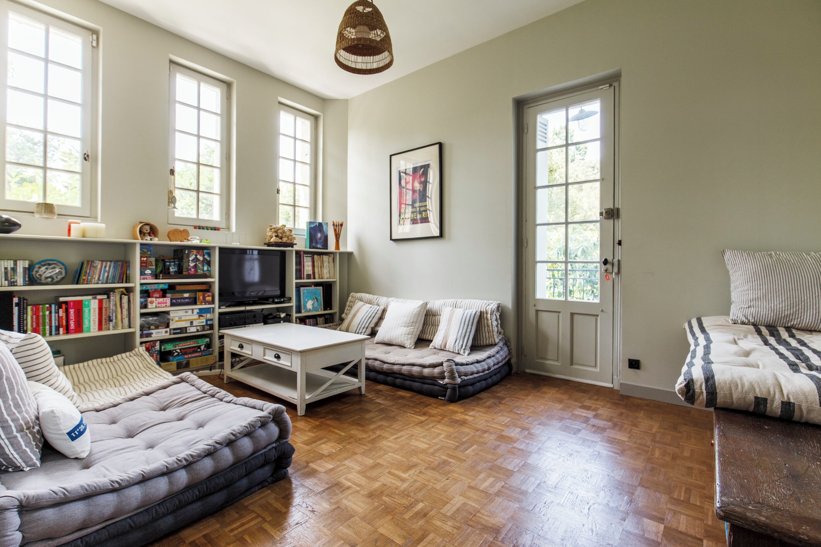 A cozy living room with a sofa, a coffee table, a bookshelf, and a television.