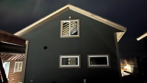Une maison avec un toit à pignon et deux fenêtres.