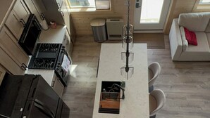 Une cuisine moderne avec un îlot central, un coin repas avec des chaises et un canapé.
