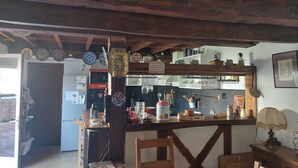 A rustic kitchen with wooden beams, a bar area, and various kitchen appliances. - House sleeps 6, parking, daily rental, 10 mmde rouen, 1 hde paris (Criquebeuf-sur-Seine)