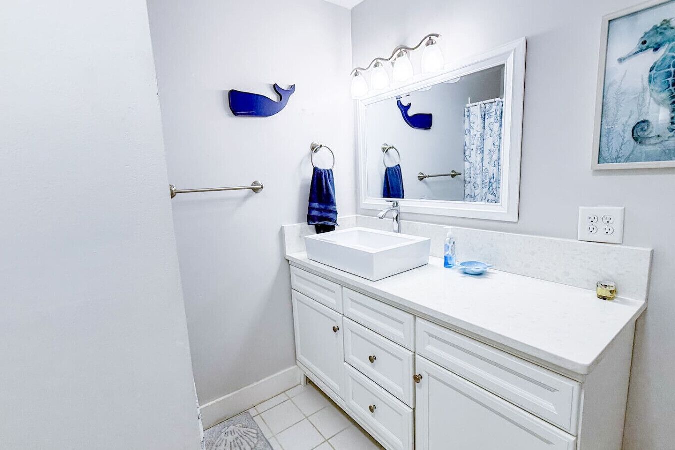 A bathroom with a white sink, a mirror, a towel rack, and a blue towel.