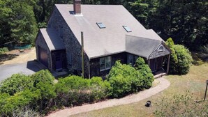 Une maison moderne avec un toit en pente, de grandes fenêtres et une cheminée.