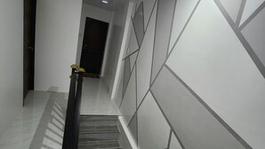 A staircase with a handrail, a door at the top, and a wall with geometric patterns.
