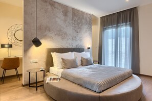 A modern bedroom with a round bed, a small side table, a lamp, and a wall-mounted light. - Luxury Villa Viktor Tireli for up to 14 guests by Istrabook (Krsan)