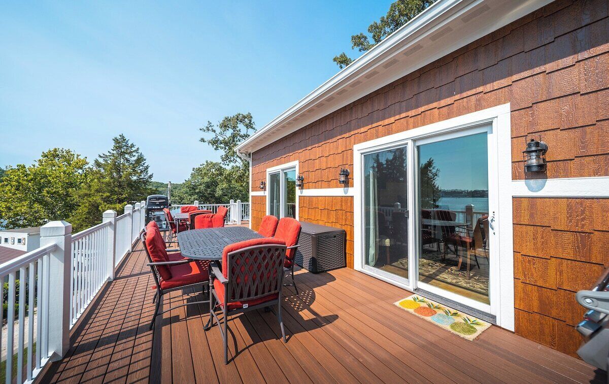 Une terrasse dotée de mobilier d’extérieur, d’un barbecue et offrant une vue sur l’eau.