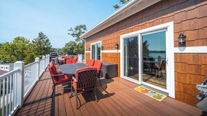 A deck with outdoor furniture, a grill, and a view of the water. - Honeysuckle House (Gravois Mills)