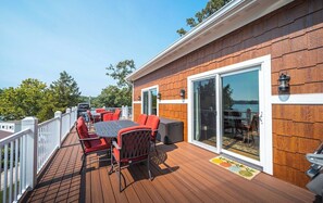 Une terrasse dotée de mobilier d’extérieur, d’un barbecue et offrant une vue sur l’eau.