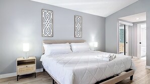 Un dormitorio con cama, lámparas de noche y ventilador de techo.