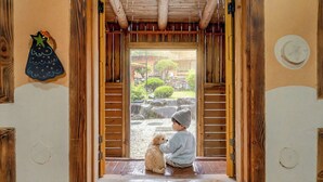A wooden interior with a sliding door leading to an outdoor garden. - Mungyeong Between Mountains Pet Pension (Mungyeong)