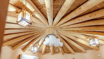 A room with a wooden ceiling, wooden beams, and hanging lantern-style lights.