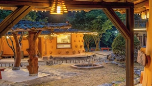 A wooden structure with a circular design, a small window, and a bench. - Mungyeong Between Mountains Pet Pension (Mungyeong)