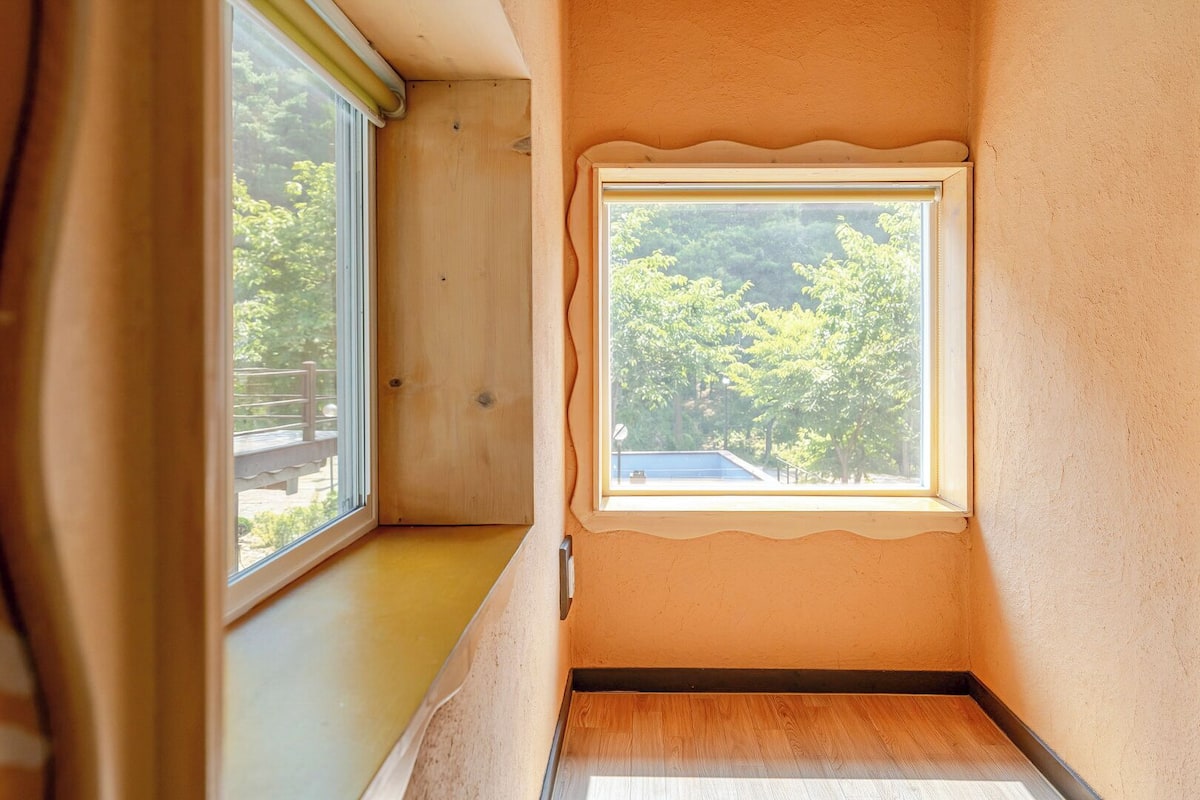 A narrow room with a window and a door.