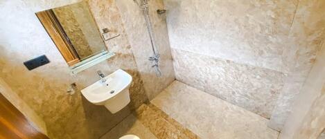 A bathroom with a shower, sink, and toilet.