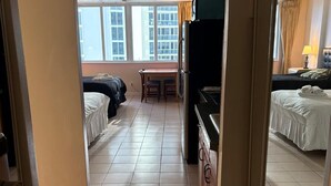 A hotel room with a bed, a desk, and a television. - Hotel Sunny Isles (Sunny Isles Beach)