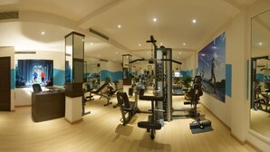 Una palestra con attrezzature per esercizi, una reception e un grande specchio.