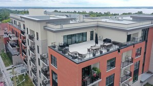 Een meerlaags gebouw met een dakterras, balkons en uitzicht op een waterlichaam.