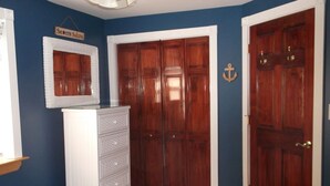 A bedroom with a bed, a dresser, a wardrobe, and a sign on the wall. - Beautiful 1-bedroom condo across the street from the beach w/ AC (Brigantine)