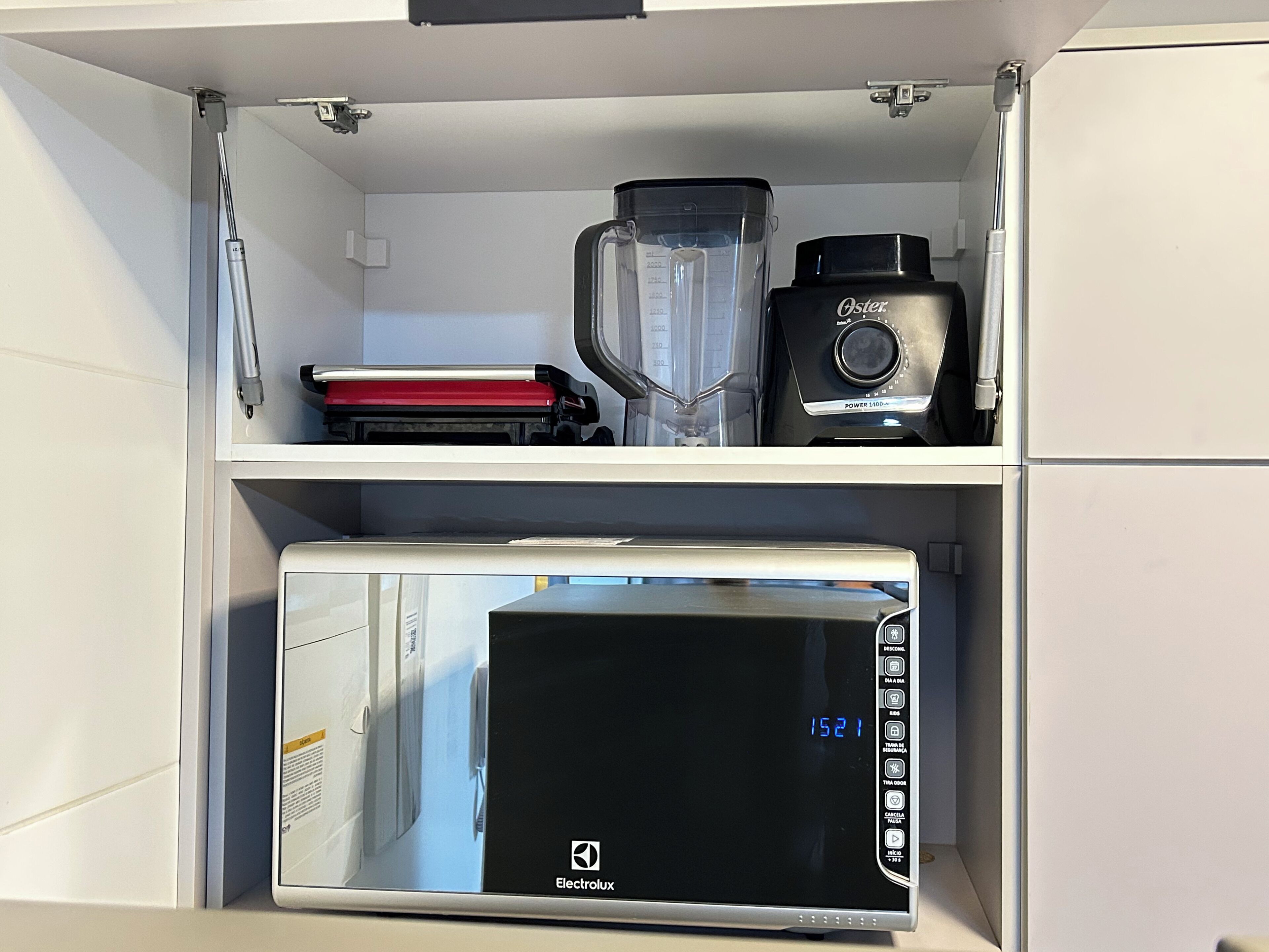 Een keuken met een blender, een koffiezetapparaat en een magnetron.