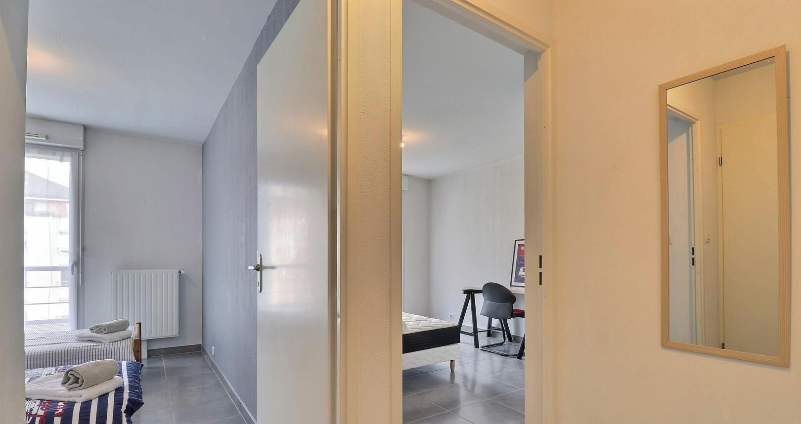 Une chambre à coucher avec un lit, une chaise, un bureau et une fenêtre.