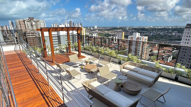 A rooftop terrace with wooden flooring, outdoor seating, and a pergola. - Melhores Flats - Linda vista (João Pessoa)